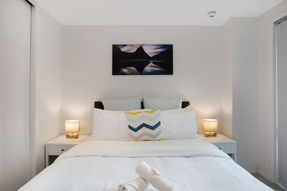 The Queen bed looks cosy and inviting with its bedside tables and soft lighting.