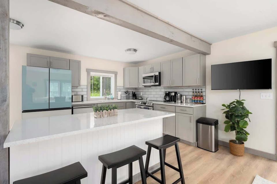 Fully stocked kitchen with stainless steel appliances, Waffle maker, pots/pans, full coffee bar, K-cup machine, french press, regular coffee machine, tea pot, and flavored syrups.
