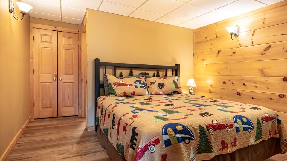Cozy bedroom with rustic mountain-themed bedding and warm cabin charm.
