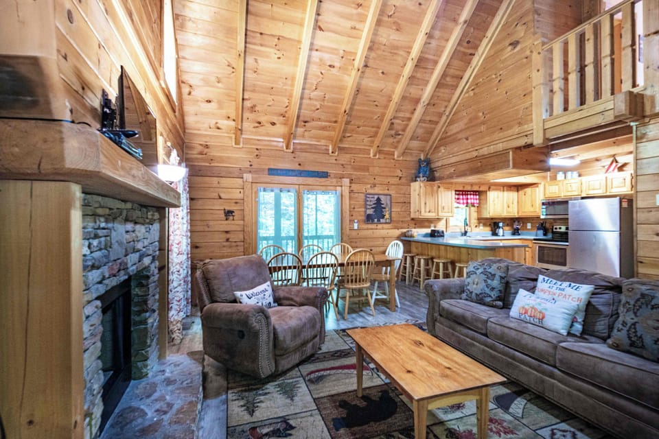 Stone fireplace, open-concept living, and a fully equipped kitchen all in one inviting space.