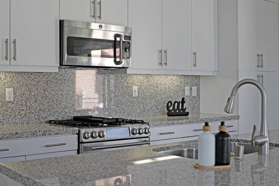Beautiful granite countertops with white cabinetry and stainless steel appliances