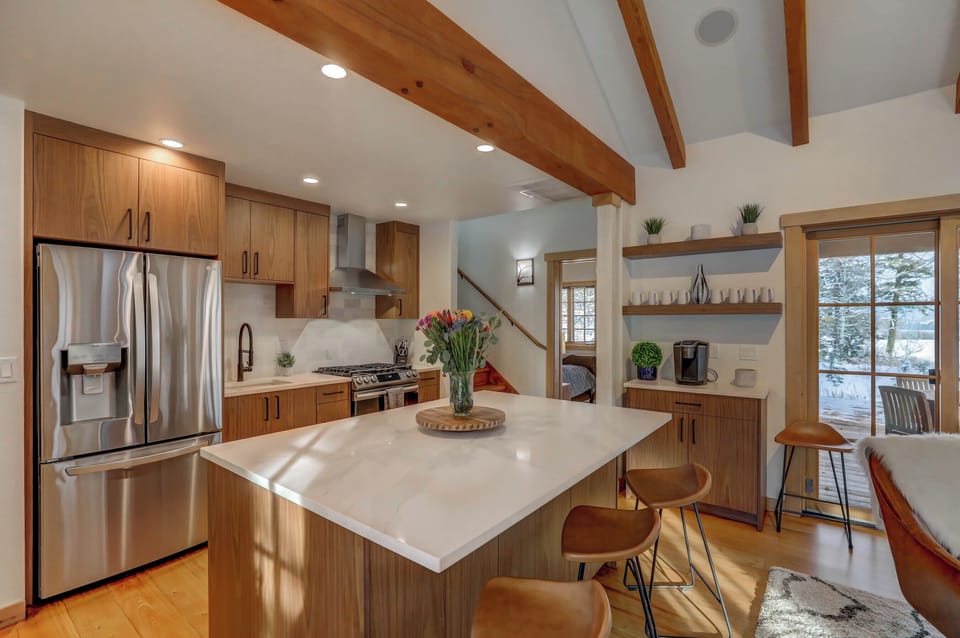New stainless appliances, custom cabinetry, and a large beautiful island that anchors the open-concept kitchen--complete with coffee bar and extra storage space
