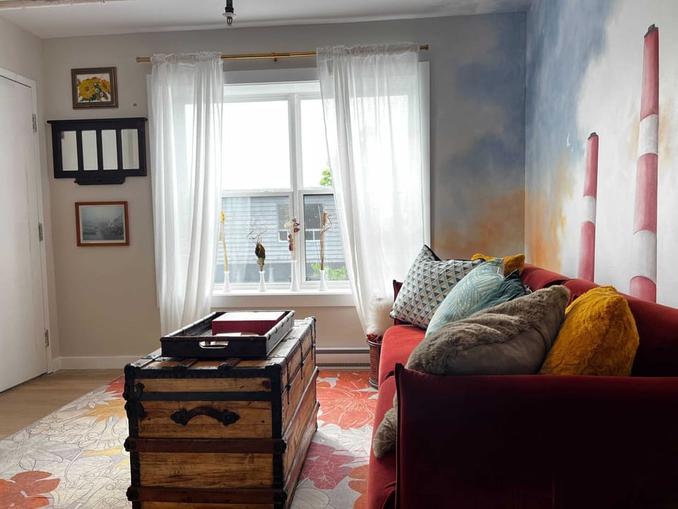 A living room inspired by the heart of Nova Scotia, featuring iconic Smokestacks wall art and a cozy sofa designed for ultimate comfort.