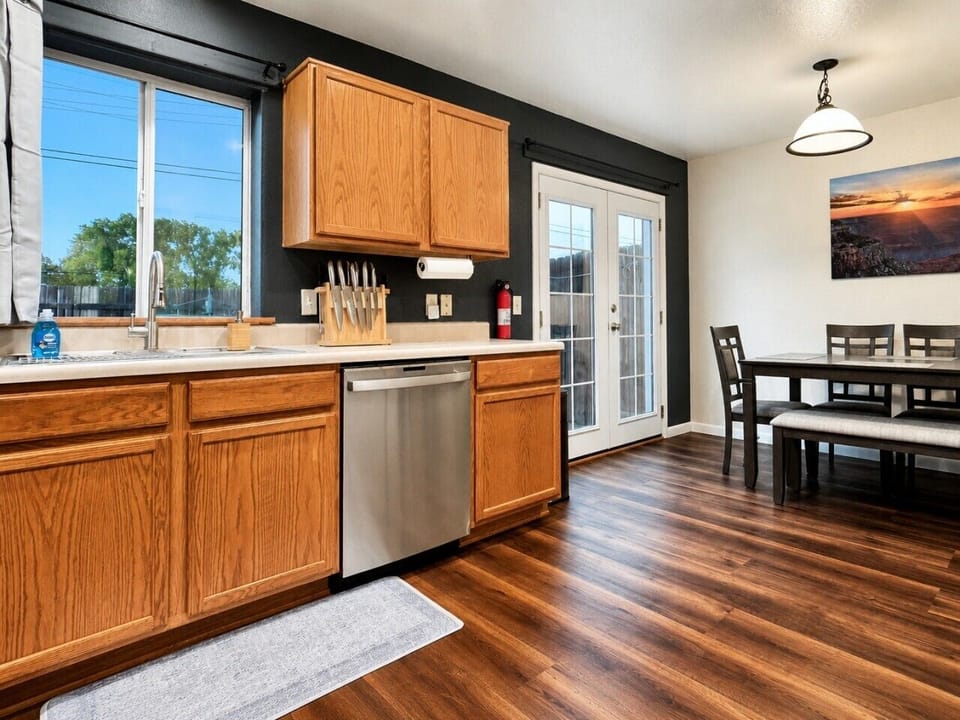 Open kitchen and dining area with warm finishes, stainless appliances, and easy access to the private patio.