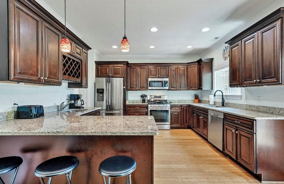 Fully stocked kitchen with granite counters and bar seating.