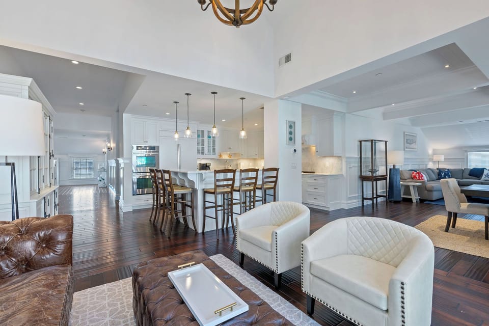 Open concept living space including a kitchen, living room and seating areas. 