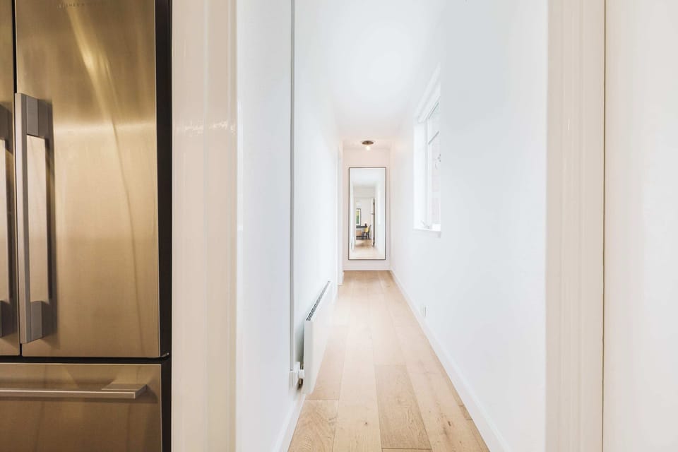 Light-filled hallway with a sleek modern design and full-length mirror