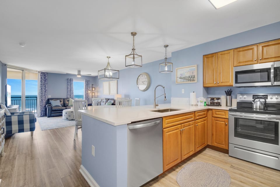 Your open-concept kitchen flows seamlessly into the living area, where ocean views greet you through floor-to-ceiling windows.