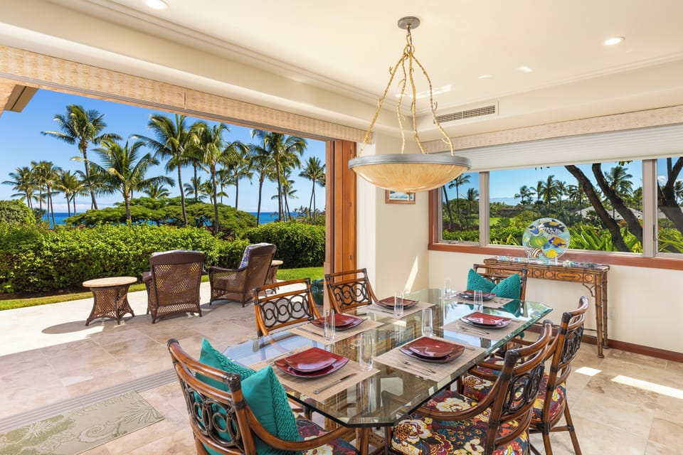 Indoor dining nook framed by sweeping views of palms and sky.