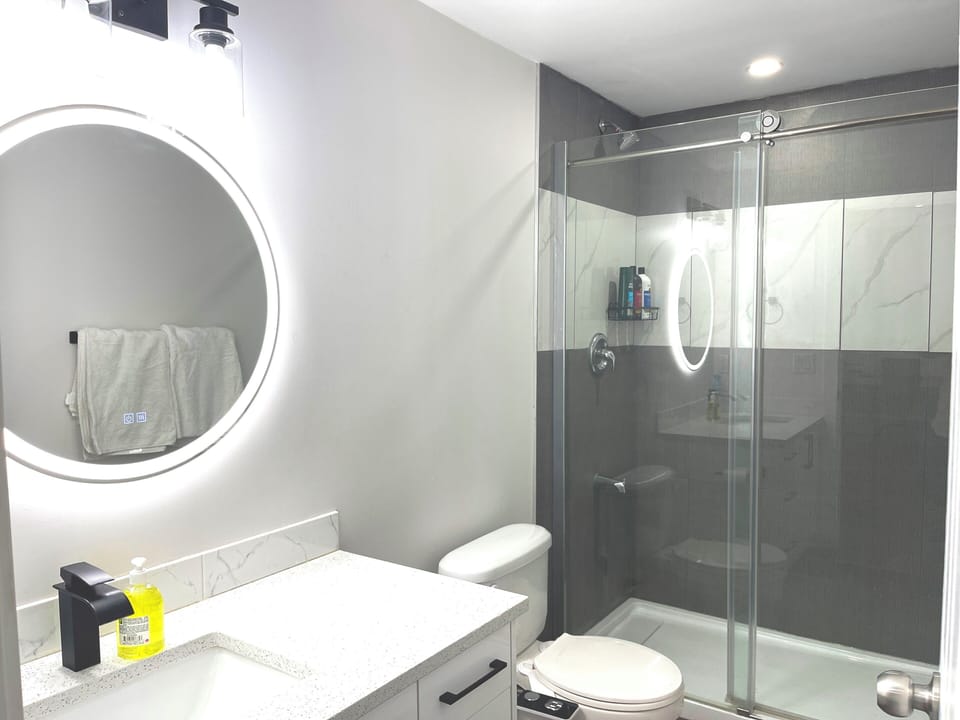 Modern full washroom with standing shower, modern mirror with light and defogger