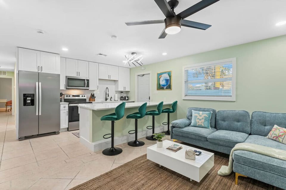 Cocoa Beach Living | Relaxed sectional, vibrant bar stools, and a kitchen island in a sun-kissed coastal setting.
