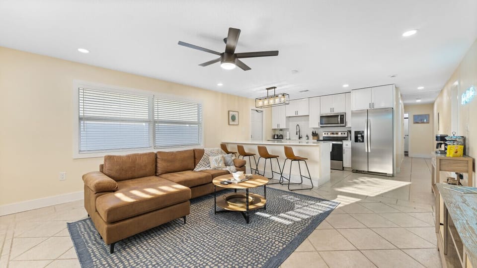 Cocoa Beach Living Room | Spacious open layout featuring a modern kitchen, comfy sectional, and easygoing coastal warmth.