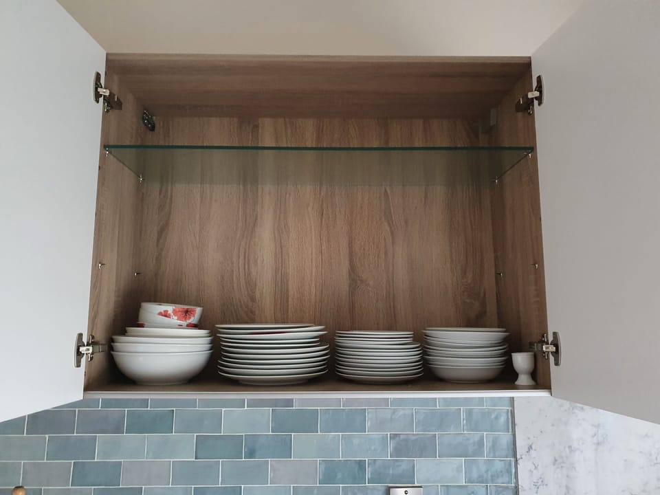 Fully stocked cupboards with lots of cutlery and appliances 