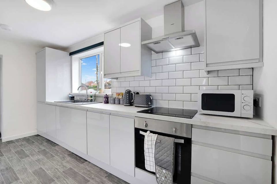 Kitchen equipped with all essentials, including a oven, fridge and full cookware set.
