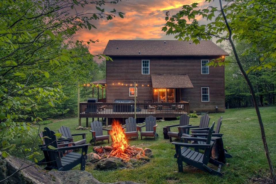 Backyard with an open fire pit, plenty of seating, and hot tub on the deck