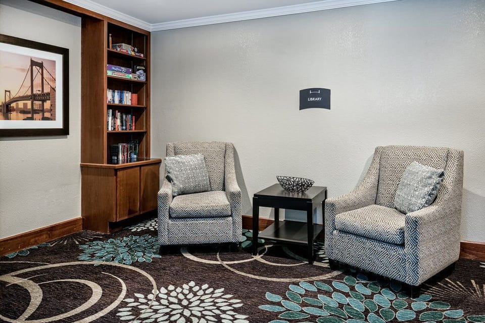 The library corner offers a quiet space with comfortable seating and shelves filled with books for guests to enjoy.