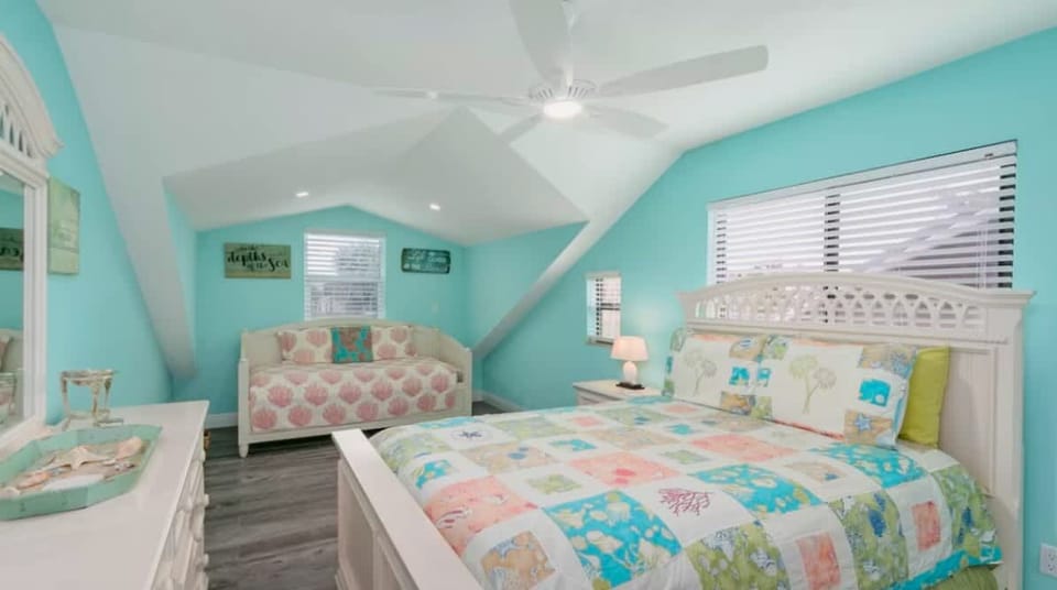 "Bright and cozy coastal-themed bedroom with a comfortable queen bed and a single day bed, and a charming daybed. Perfect for a relaxing seaside getaway."