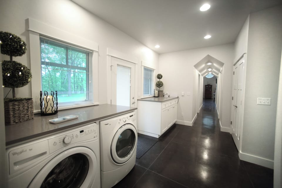 Laundry room with vaulted hallway leading to bedrooms and living area
