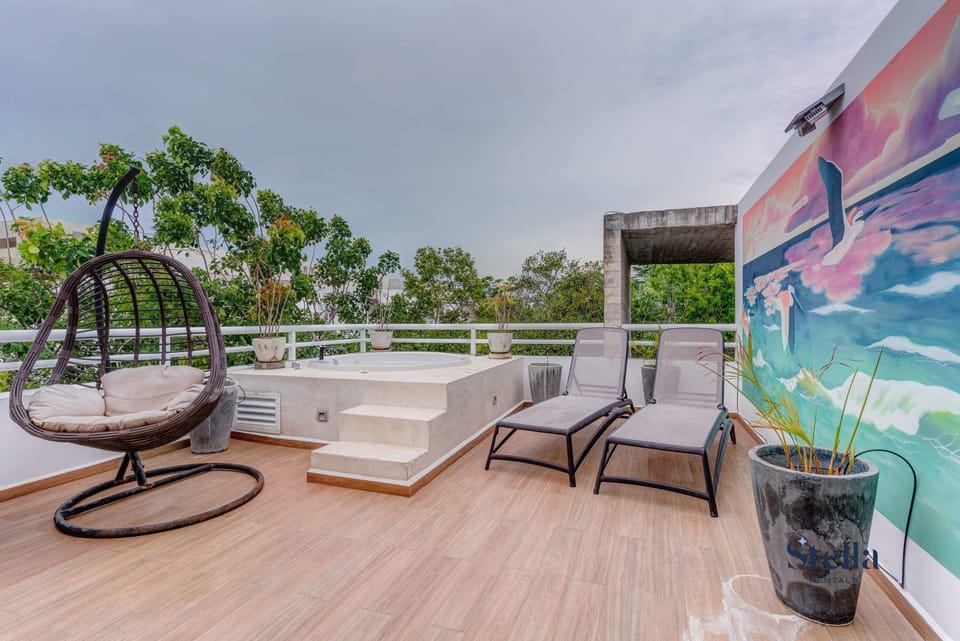 Your own private jungle rooftop lounge with a spa tub overlooking lush foliage