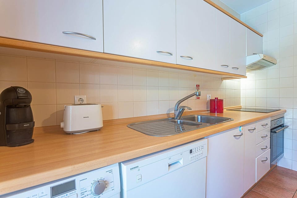 Modern kitchen with wooden worktops and white cabinetry — Apartment Ciprestes, holiday apartment in Portugal