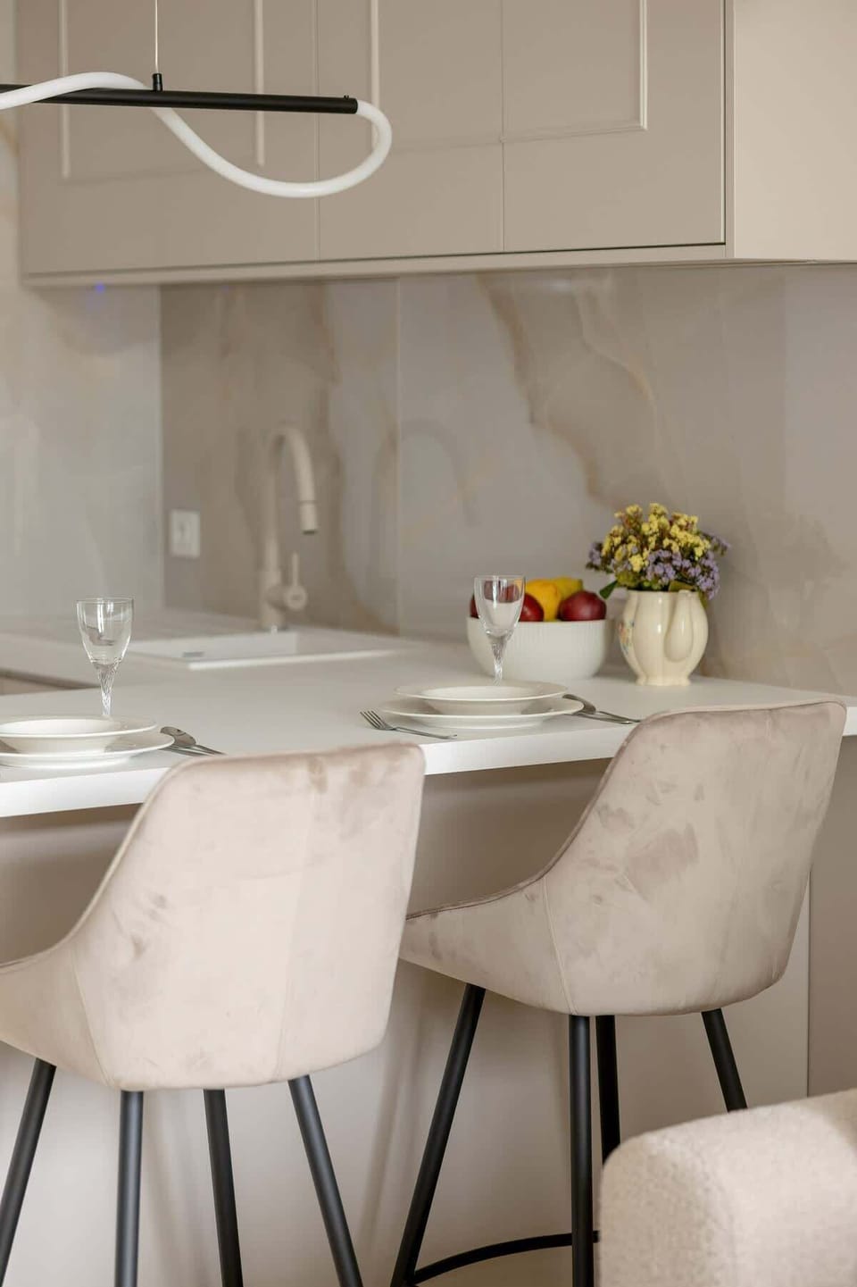 Dining area with modern white chairs around a wooden table and minimalist decor.
