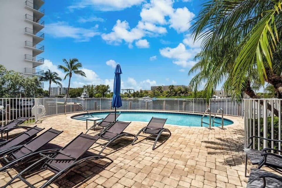 The community pool deck has plenty of lounge chairs beside the water.