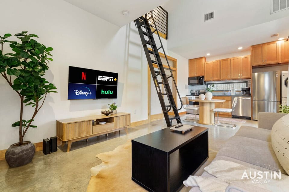 Beautiful living room with comfy sofa, smart tv, and stairs to the loft
