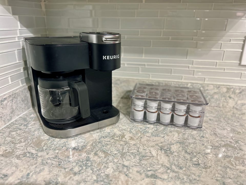 Fully stocked coffee bar including k-cups, creamers, and sweeteners.