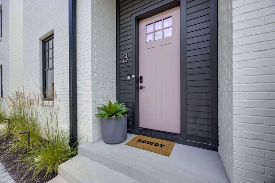 A welcoming pink front door and perfectly styled entryway set the tone for the colorful experience inside.