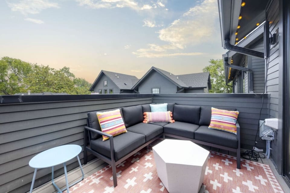 The rooftop terrace is set up for golden hour vibes with plush seating and views stretching over the neighborhood.