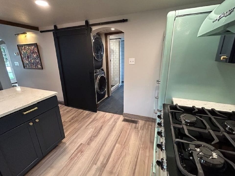 Kitchen looking toward washer/dryer and pantry shelving.