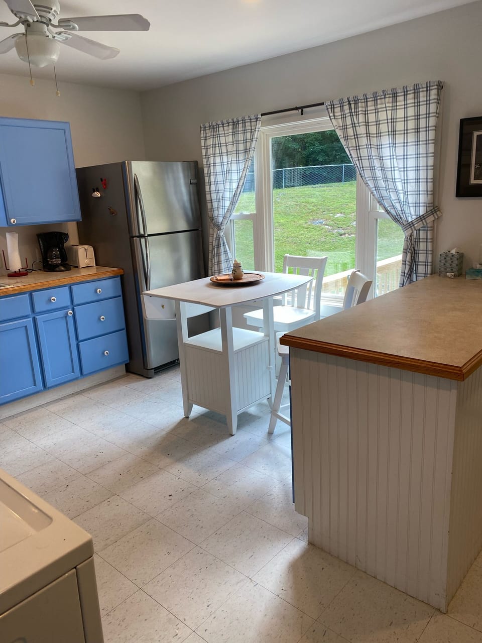 Kitchen from living room entrance. Fence around the yard is visible thru window.