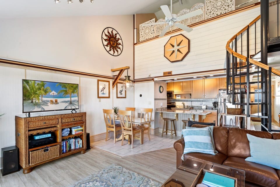 The open-concept Main Level boasts a cozy Living Area with high ceilings, a large Flat Screen TV, and a wall with windows and glass sliders overlooking the Pamlico Sound!