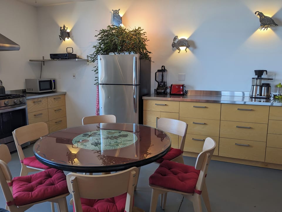 full kitchen: fridge, stainless counters, drawers, coffee maker & grinder