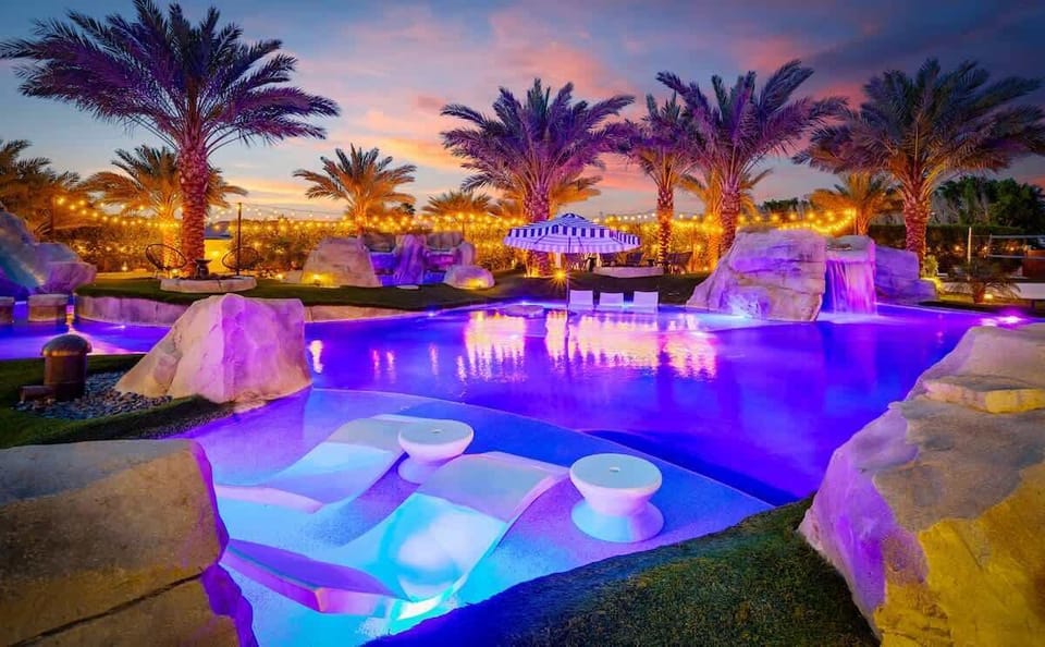 As the sun dips below the horizon, the resort pool glows with ambient lighting and vibrant hues.
