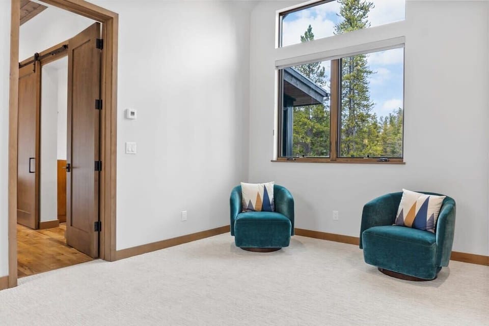 The main level bedroom features a sitting area with two stylish royal blue chairs.