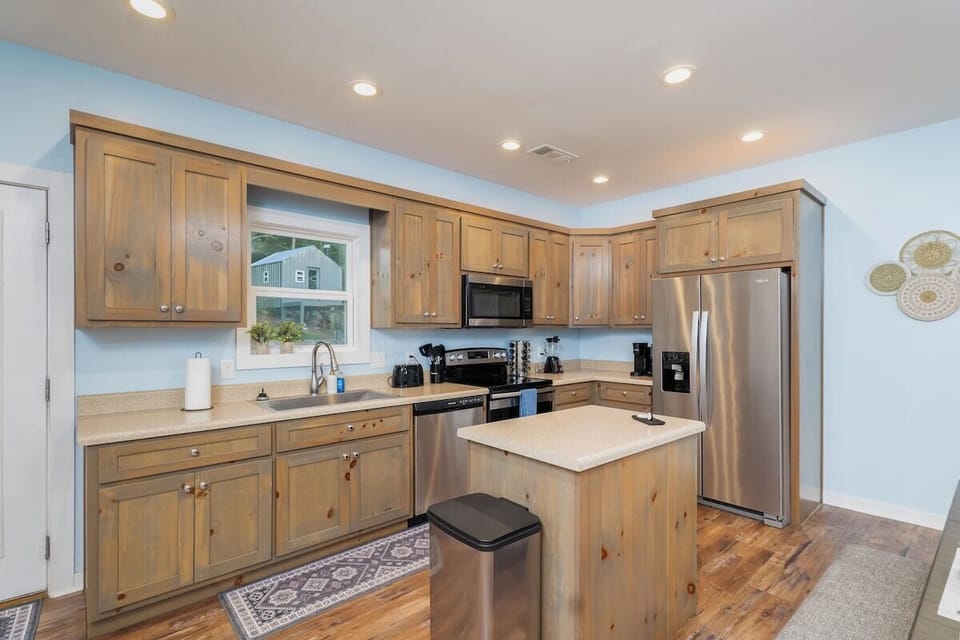 Fully stocked kitchen with cookware, cups, knives, coffee makers, wine glasses
