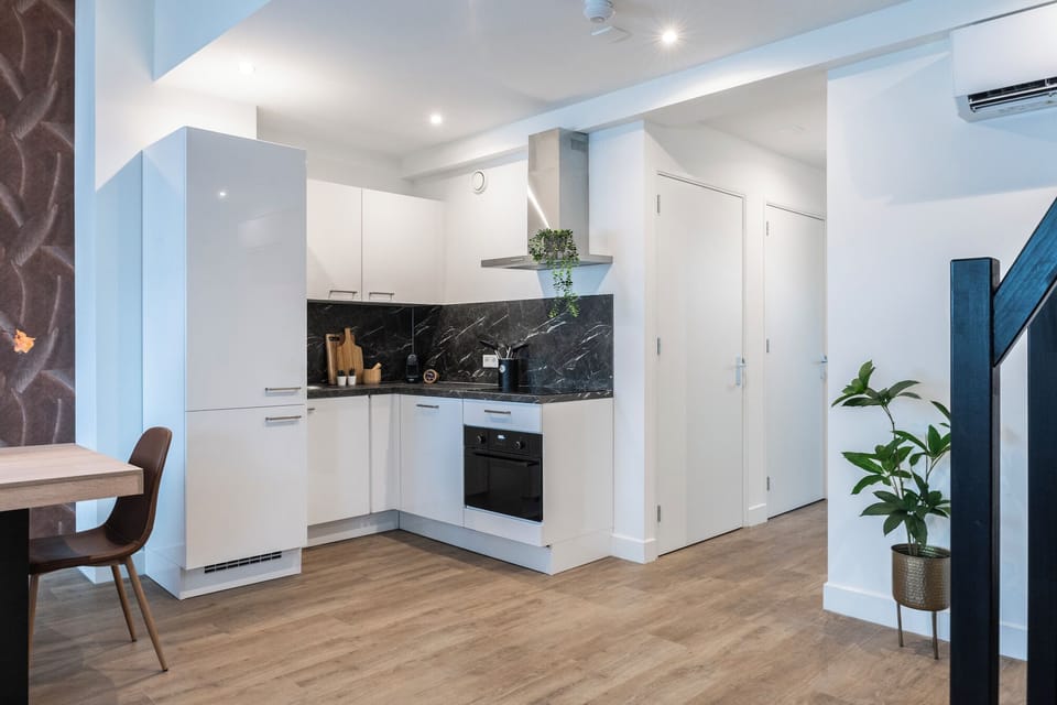 A modern kitchen area with sleek appliances and stylish cabinetry, offering a functional and clean design.