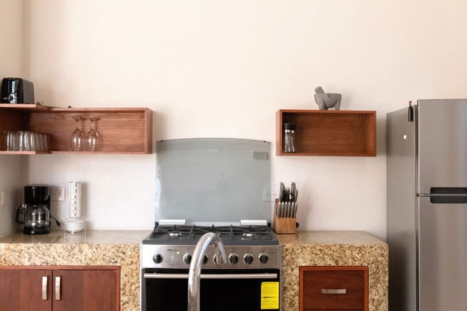 Unleash your inner chef in our luxurious Tulum villa kitchen, complete with an oven, dishwasher, and all the essentials for gourmet adventures