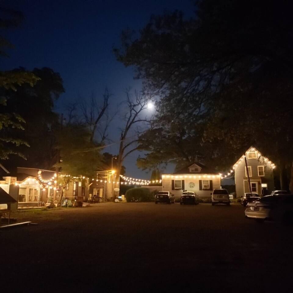 The parking lot area at the top of the hill. The Blue Roof Cottage is located further down the driveway and has more privacy away from the cottages. Super short walk (less than a minute) to get to the beach, rooftop deck, and common areas.