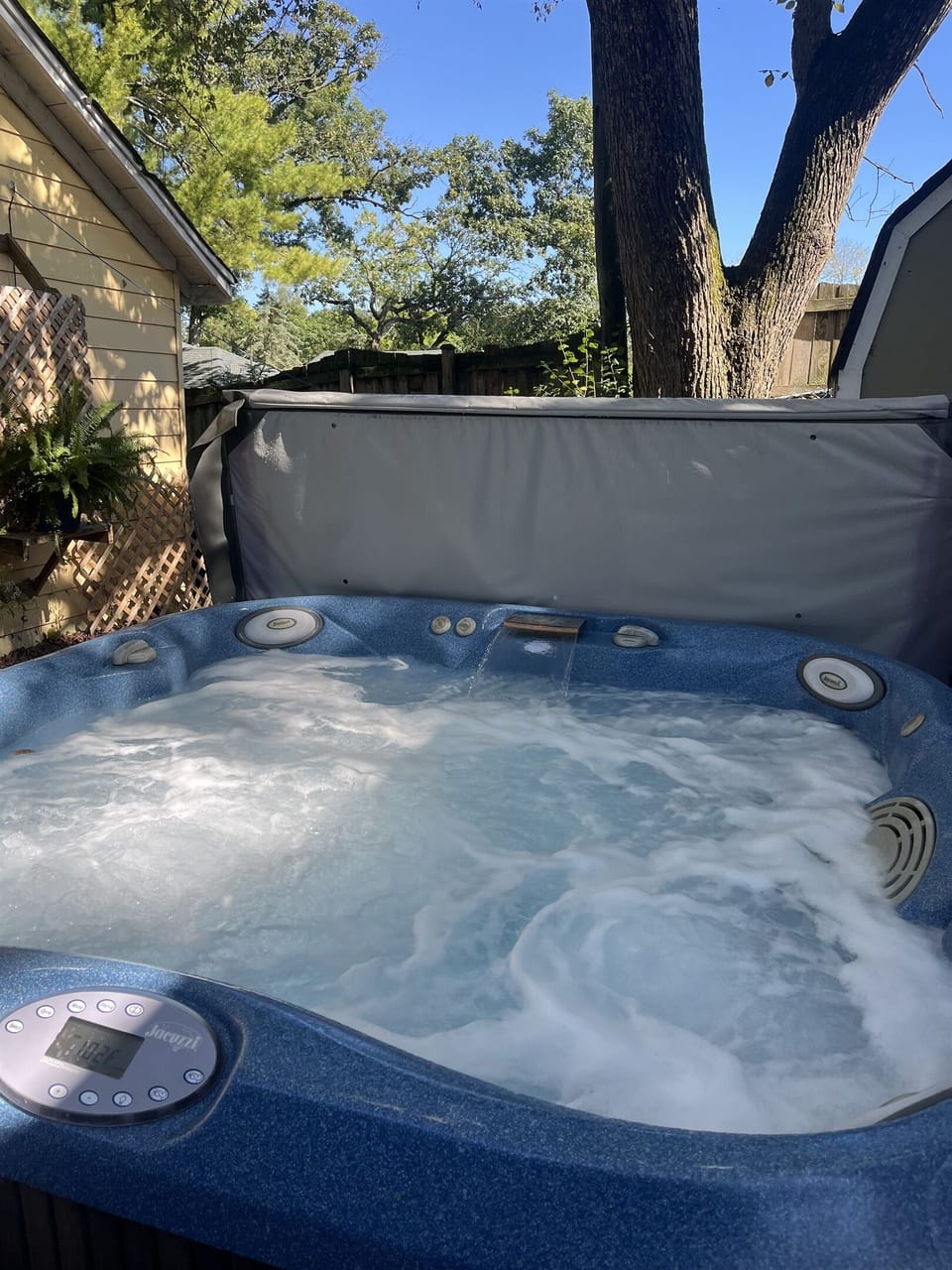 Private hot tub that seats 5 is located in a patio next to cottage.