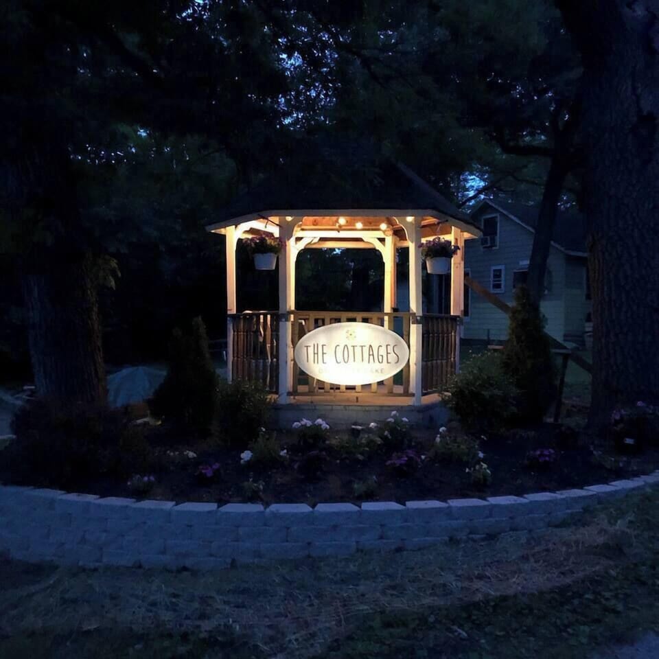 Gazebo is lit up at night and has seating inside.