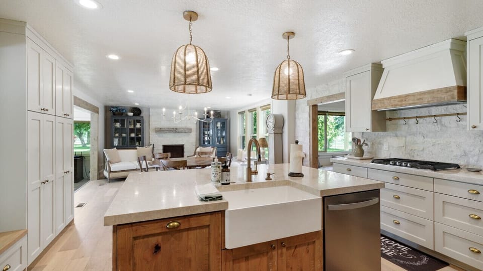 Seamlessly blending elegance and functionality: a chic kitchen with golden accents flowing into a cozy living room