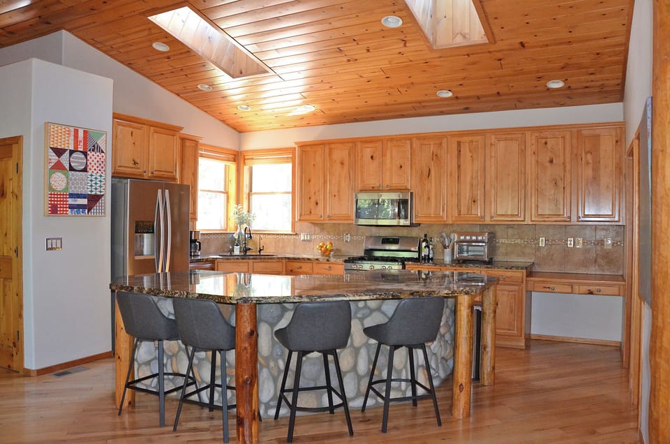 kitchen with island seating. Laundry room and pantry have doors on the right