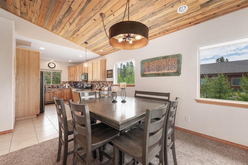 - Dining area with rustic wood ceiling and lighting   - Open layout connects to kitchen and living room   - Perfect space for family meals and gatherings