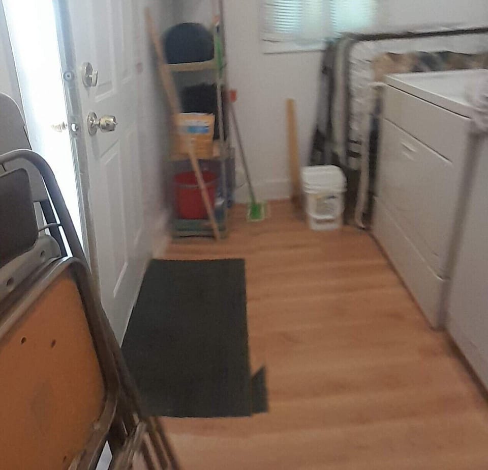 CO monitor is plugged in near the gas dryer. Broom, vacuum, and mop are here.