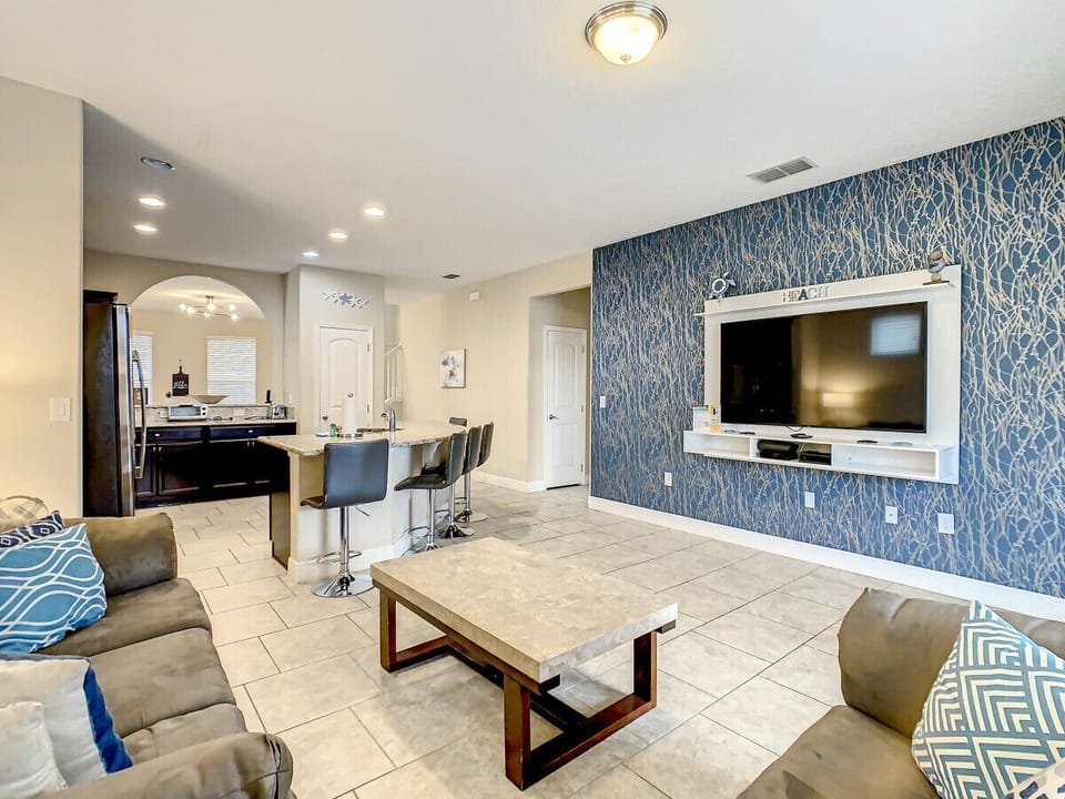 Cozy living room with cozy couches, flat-screen TV and breakfast island