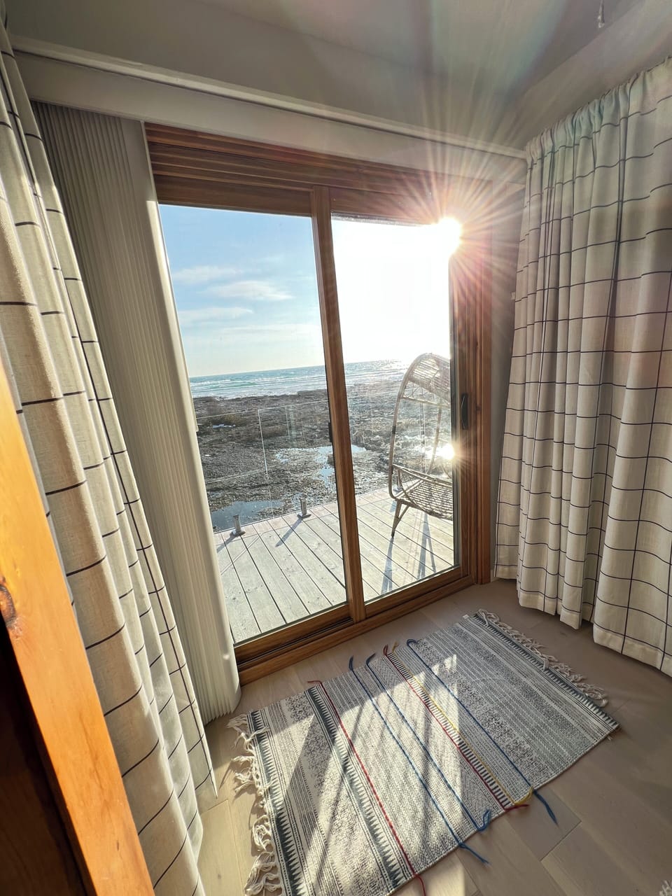 Bedroom 2: Let the sunshine in! This cozy corner opens to a private deck with incredible lake views—perfect for morning coffee or golden hour glow.