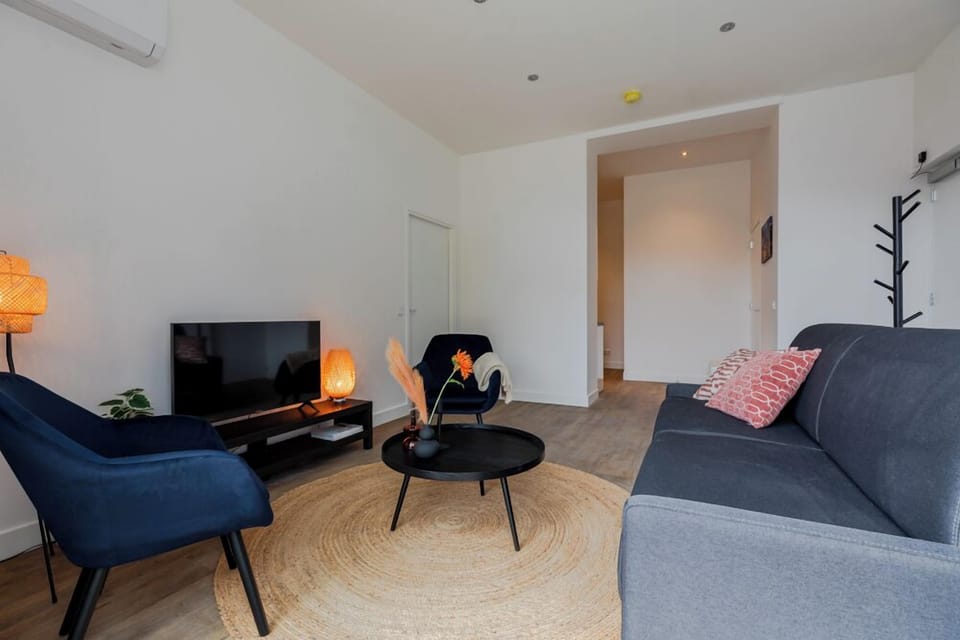 Chic living space furnished with comfortable sofas and stylish accents, creating a welcoming environment for relaxation and entertainment. Located near Bed en Koffie, Tilburg Centrum, perfect for a cozy stay with easy access to Tilburg's main attractions, including the University and safaripark Beekse Bergen, all at an affordable price.