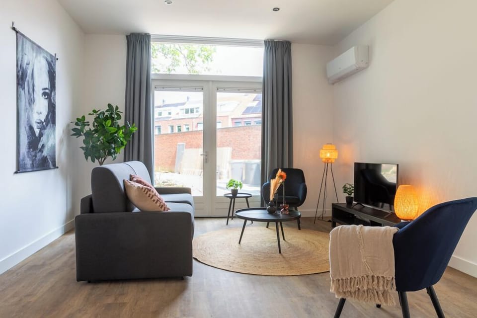 Stylish living area with a comfortable seating arrangement, accented by a striking portrait and warm ambient lighting, perfect for relaxing evenings.

A great option for affordable overnight stays near Safaripark Beekse Bergen. Experience nature and comfort!
